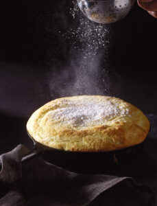 A dusting of confectioners’ sugar completes the cast iron skillet lemon soufflé.